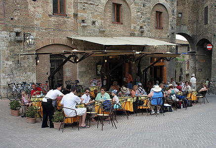 group of people dining outside brown concrete building thumbnail