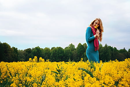 woman in blue dress on field of yellow flower thumbnail