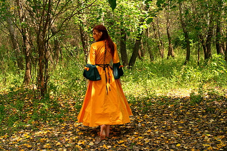 woman wearing yellow dress walking in middle of forest thumbnail