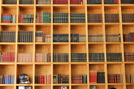 books and football helmet in brown wooden cubby shelf thumbnail