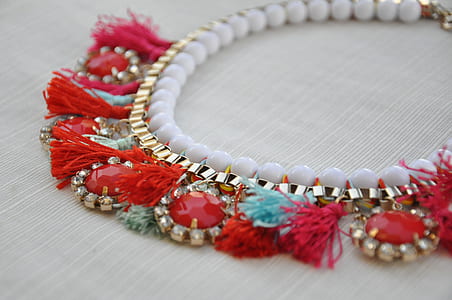 focus photography of beaded red and gold-colored necklace thumbnail