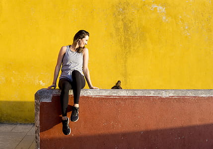 Smiling Woman Sitting on Orange Barrier thumbnail