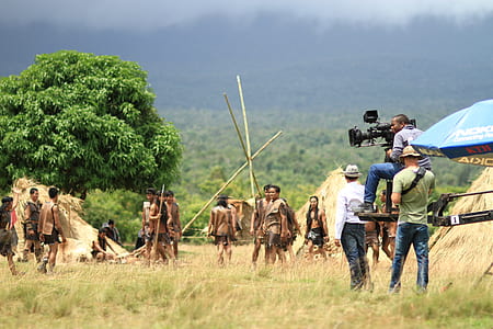 men shooting movie on grass field during daytime thumbnail