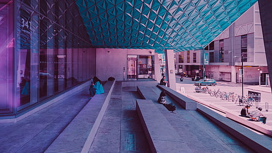 photo of person sitting on pavement near glass wall thumbnail
