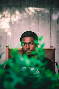 man in black top seating on brown wooden chair thumbnail