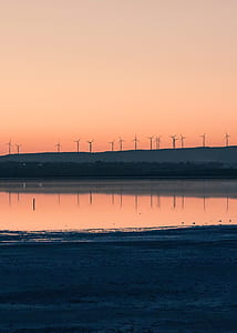 silhouette of wind turbines on mountain thumbnail