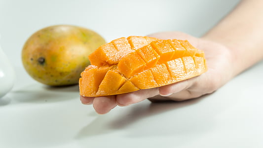 slice mango on person's hand thumbnail