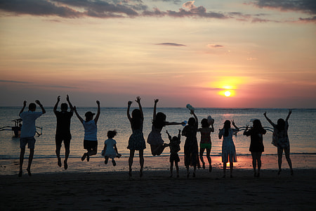 people jumping together at the beach during golden hour thumbnail