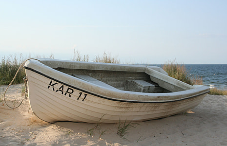 white outboard boat on sand near shore thumbnail