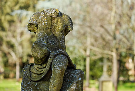 selective focus photography of no head statuette near trees at daytime thumbnail