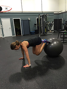 person wearing black tank-top shirt and black training short using black stability ball thumbnail