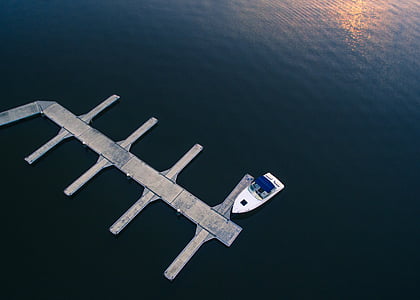 white speedboat docking on dock thumbnail