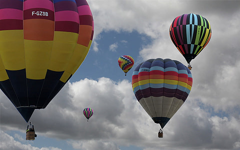 five assorted-color hot air balloons floating mid air under columbos clouds thumbnail