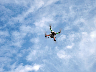 white low-angle photography of multicolored quadcopter on mid air under white clouds and blue sky during daytime thumbnail