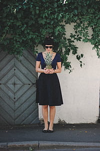 Woman Holding Pineapple Standing Beside Wall thumbnail