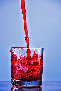 pouring red beverage in clear rocks glass thumbnail