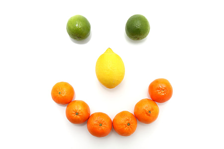 orange fruits and lemon formed smiley on white surface thumbnail