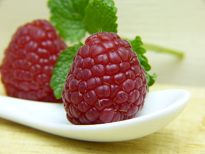 two red raspberries on white ceramic tray thumbnail