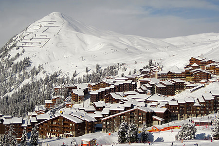 high angle photo of house near snow mountain thumbnail