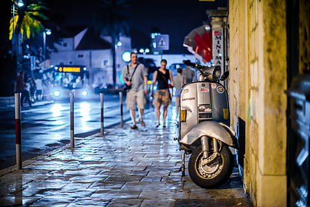 two man walking towards gray motor scoote thumbnail
