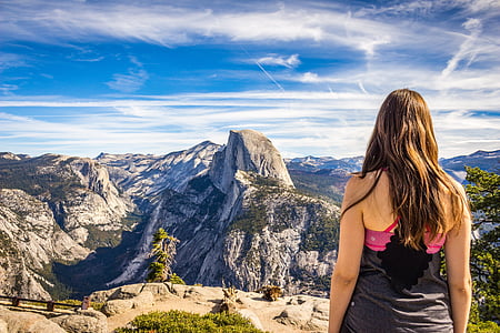 woman standing on hill near mountains thumbnail