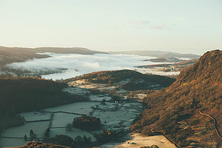 aerial view of mountains and body of water thumbnail
