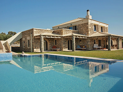 brown concrete house near swimming pool during daytime thumbnail
