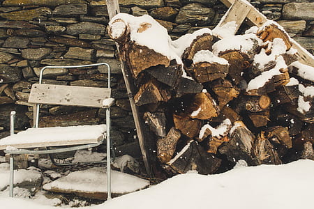 brown firewoods covered with snow thumbnail