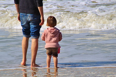 man in blue denim shorts standing beside girl in pink hoodie and brown shorts on body of water thumbnail