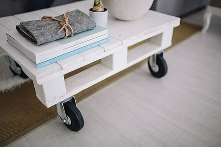 Small wooden table with a potted plant and a grey wallet thumbnail