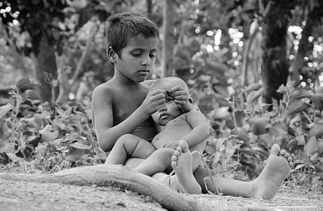 grayscale photography of boy carrying toddler thumbnail