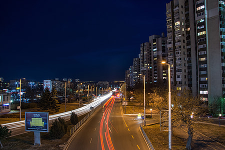 gray buildings with passing cars during night thumbnail