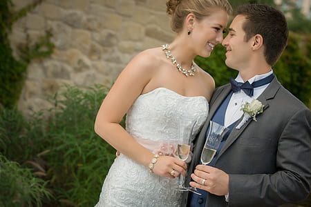 smiling woman beside smiling man holding white wines thumbnail