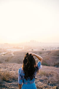 woman holding her hair standing on mountain thumbnail