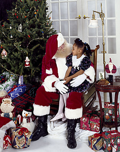 person wearing Santa Claus costume while talking to girl beside Christmas tree thumbnail