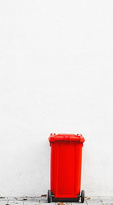 orange trash bin beside wall thumbnail
