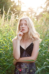Woman Pointing Her Lips While Standing Beside Plants thumbnail