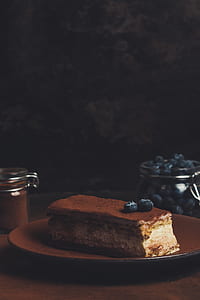 sliced cake on brown plate near jar of blueberries thumbnail