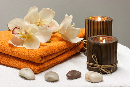 two brown wooden candle holder near orange blanket thumbnail