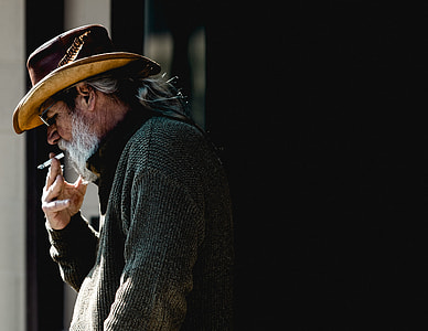 man smoking cigarette wearing hat thumbnail
