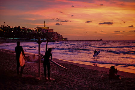 man and woman holding surfboard standing on seashore thumbnail