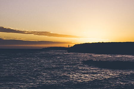 body of water beside mountains in sunset thumbnail