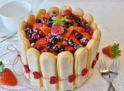 round strawberry cake beside two table forks thumbnail