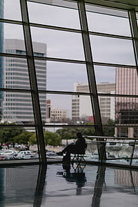 person sitting on chair near glass window thumbnail