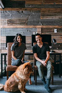 photo of two person and dog sitting on room thumbnail