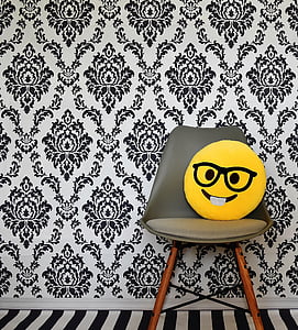 yellow emoji pillow on brown wooden framed gray padded chair thumbnail