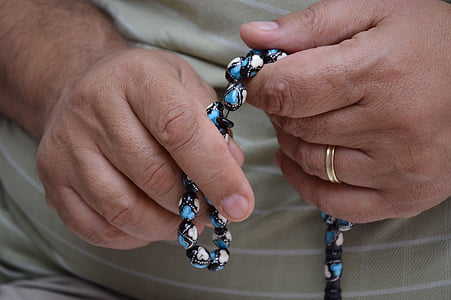 person holding misbaha prayer bead thumbnail