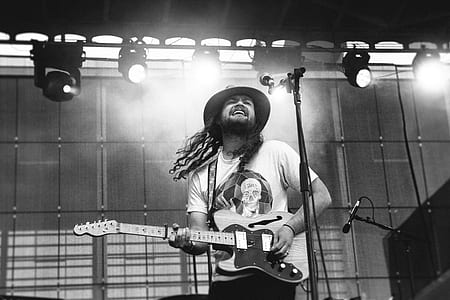 man playing guitar while singing on stage thumbnail