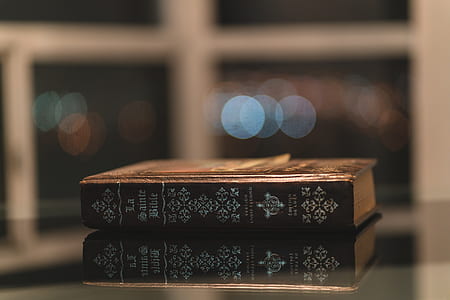 brown bible on glass-top table thumbnail
