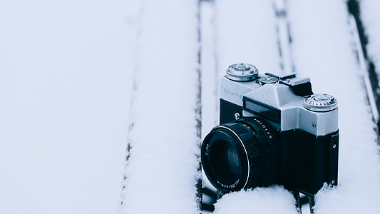 black and gray mirrorless camera on snow covered surface thumbnail